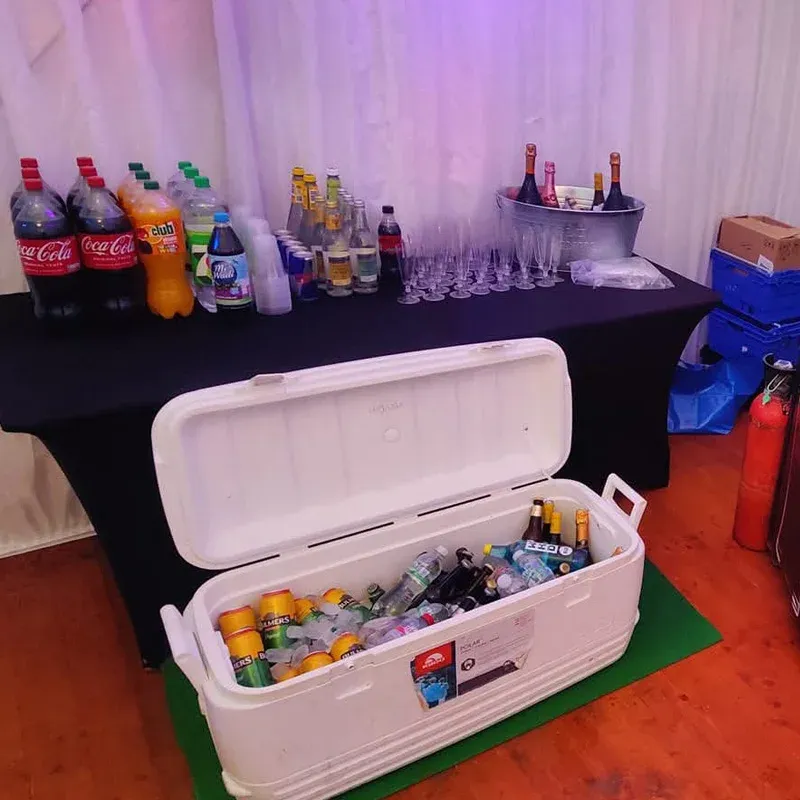 Polar box of mixers and bottles beside the bar