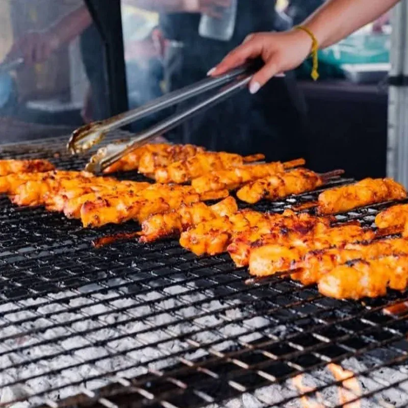 Chicken skewers cooking over charcoal